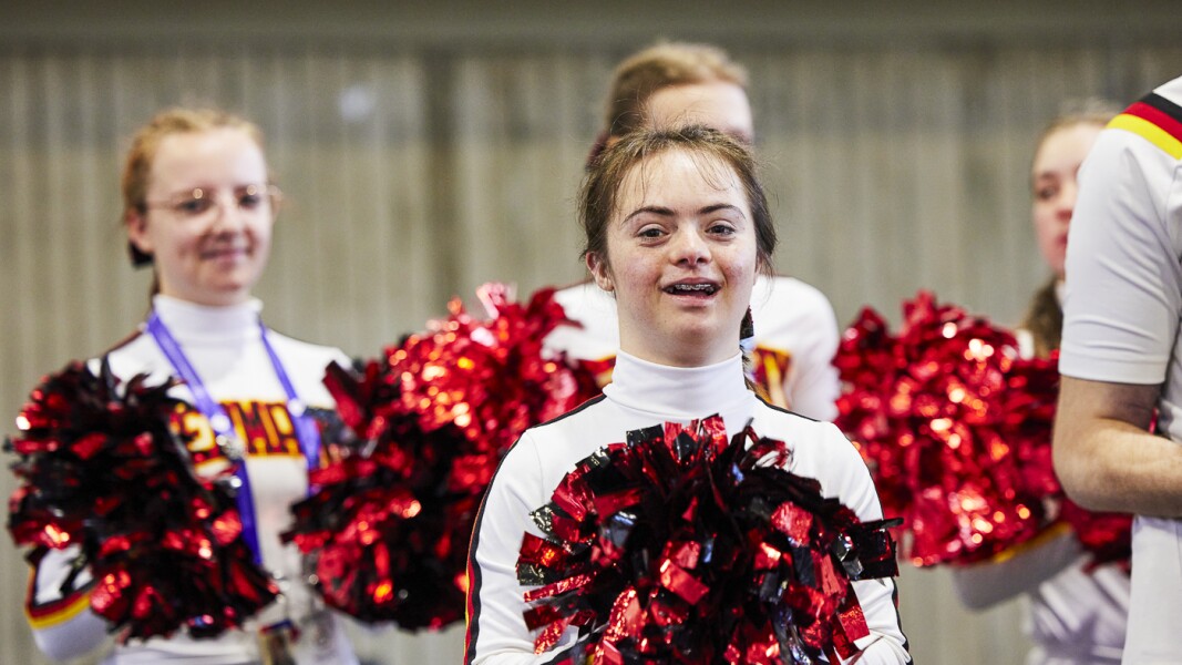 Das Foto zeigt junge Special Olympics Cheerleaderinnen mit ihren Pompoms.