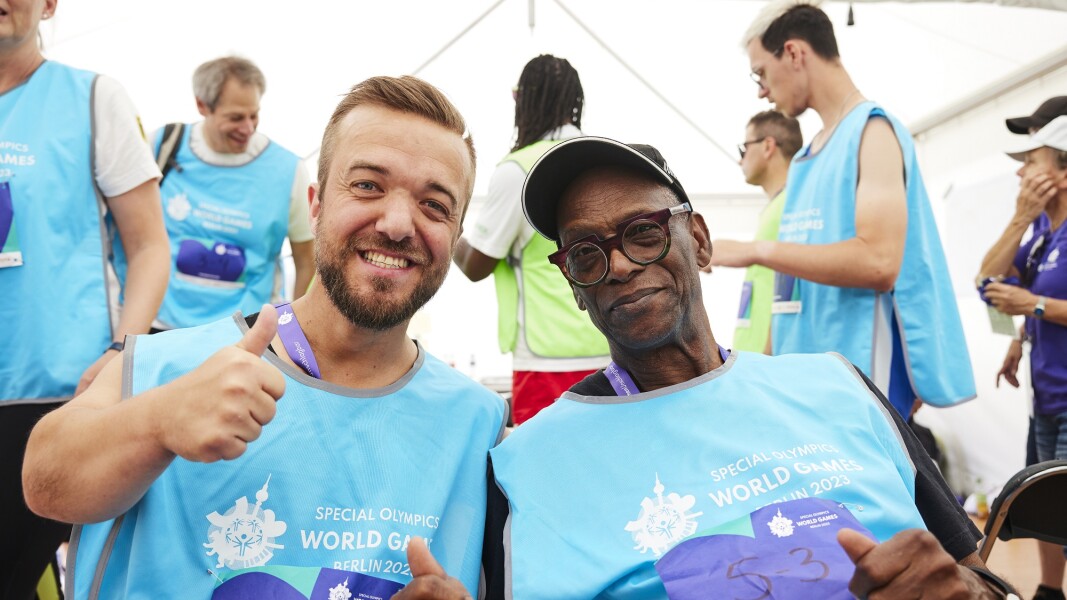 Two athletes smile for the camera.