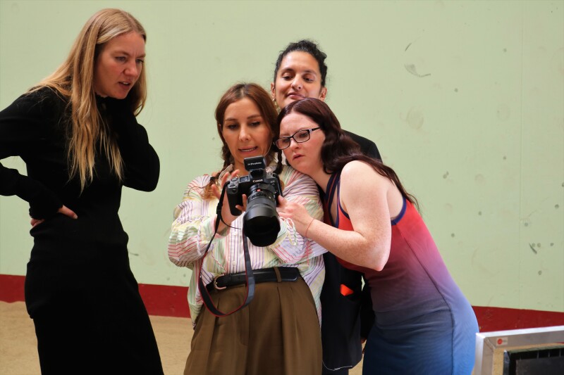 Das Foto zeigt einen Sportler und das Shooting-Team während einer kurzen Pause beim Shooting mit der Vogue. Sie sind gut gelaunt und schauen sich Bilder auf der Kamera an.