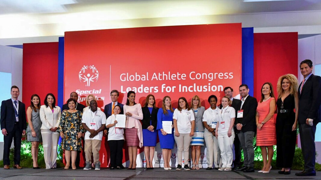 Auf dem Foto stehen mehrere Leute nebeneinander. Sie sehen freudig.