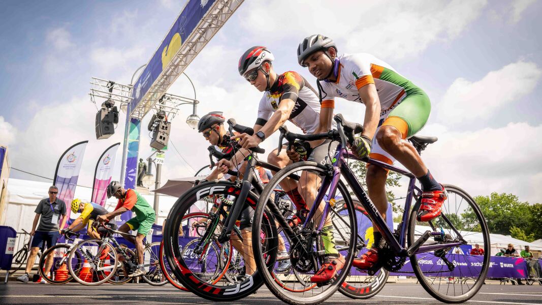 The photo shows several cyclists in colorful jerseys. They look very concentrated, but here and there some are smiling.