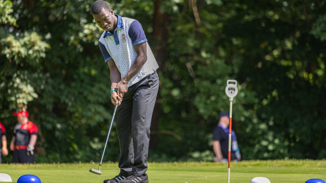 DE: Ein Golfspieler schaut seinem Ball hinterher.
