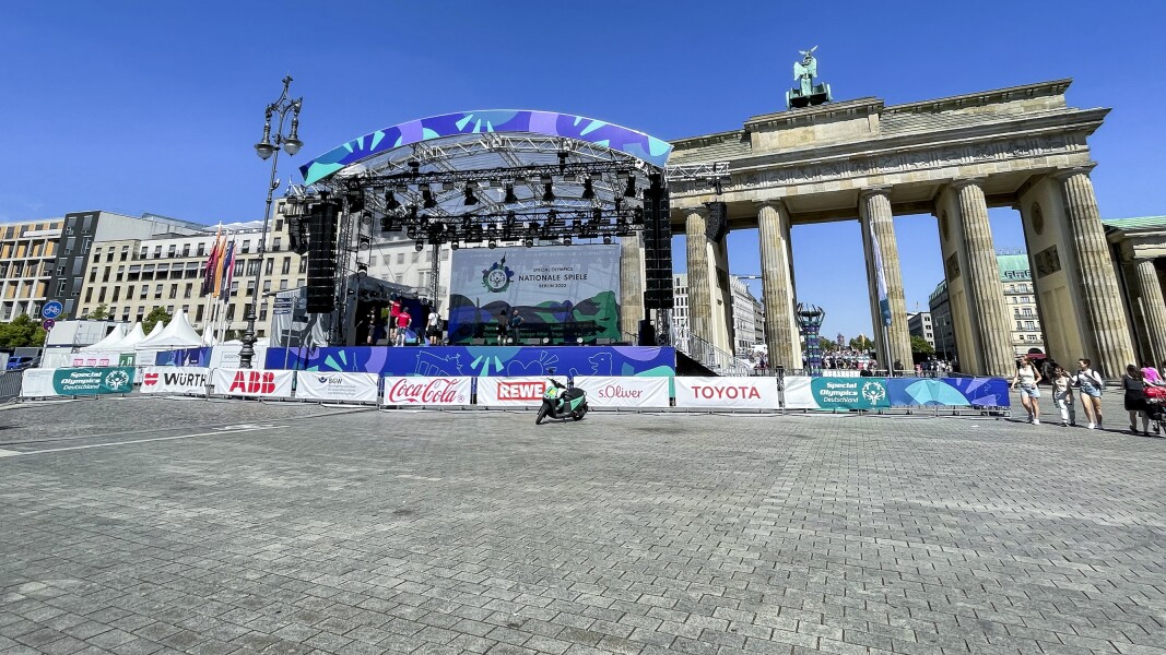 Das Foto zeigt den Platz vor dem Brandenburger Tor. Man sieht eine Bühne und viele Sponsorenbanner.