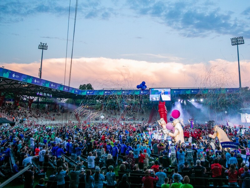 Das Foto zeigt eine Partyszene während der Eröffnungsfeier der Special Olympics Nationalen Spiele Berlin 2022. Viele Menschen feiern gemeinsam im Stadion An der Alten Försterei in Berlin-Köpenick.