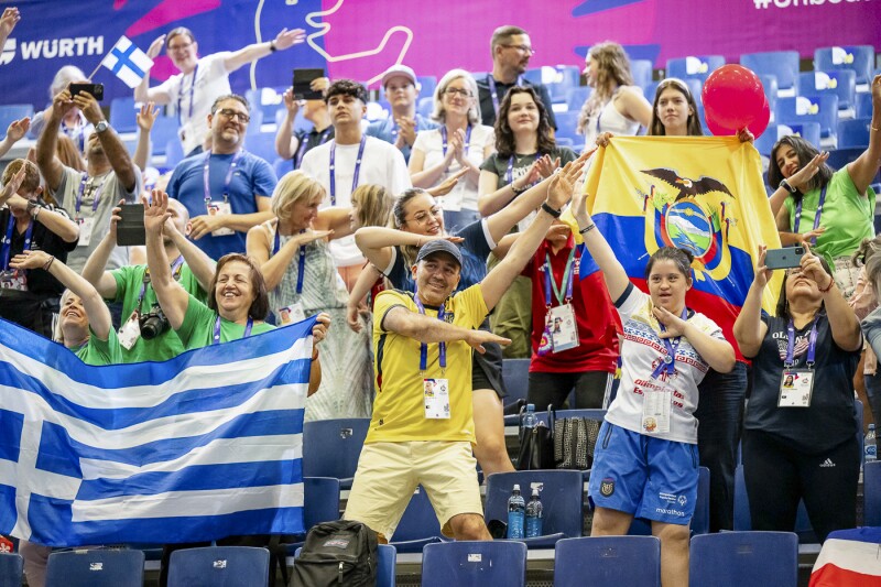 Auf dem Foto sind Fans zu sehen. Sie feuern die Athlet*innen an und freuen sich mit ihnen.