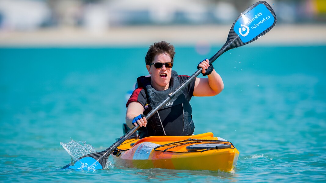 Das Foto zeigt die deutsche Kanu-Athletin Juliane Rößler. Sie hält ein Paddel in der Hand und trägt eine Schwimmweste.