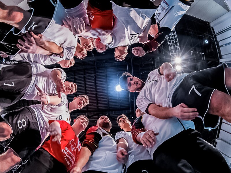 The photo shows a Volleyball team in a circle from below during their time out.
