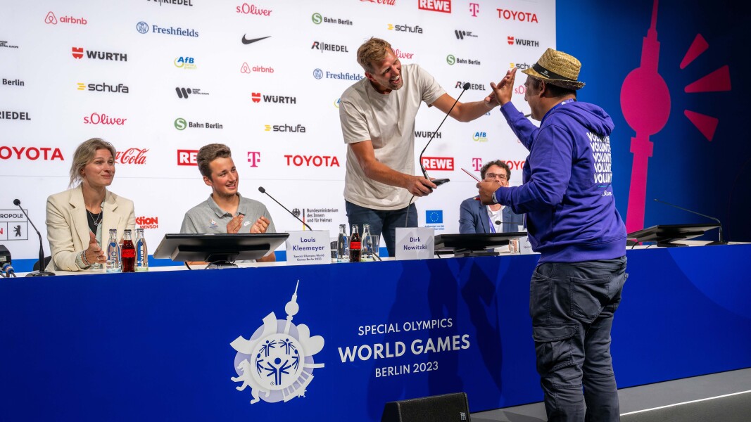 Auf einer Pressekonferenz gibt Basketballer Dirk Nowitzki einem Volunteer, der ihm eine Frage stellt, ein Highfive.