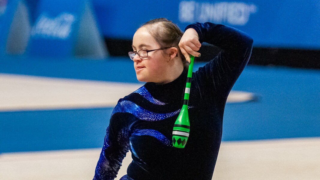 Das Foto zeigt eine Athletin bei der Rhythmischen Sportgymnastik. Sie hat zwei Keulen in den Händen.