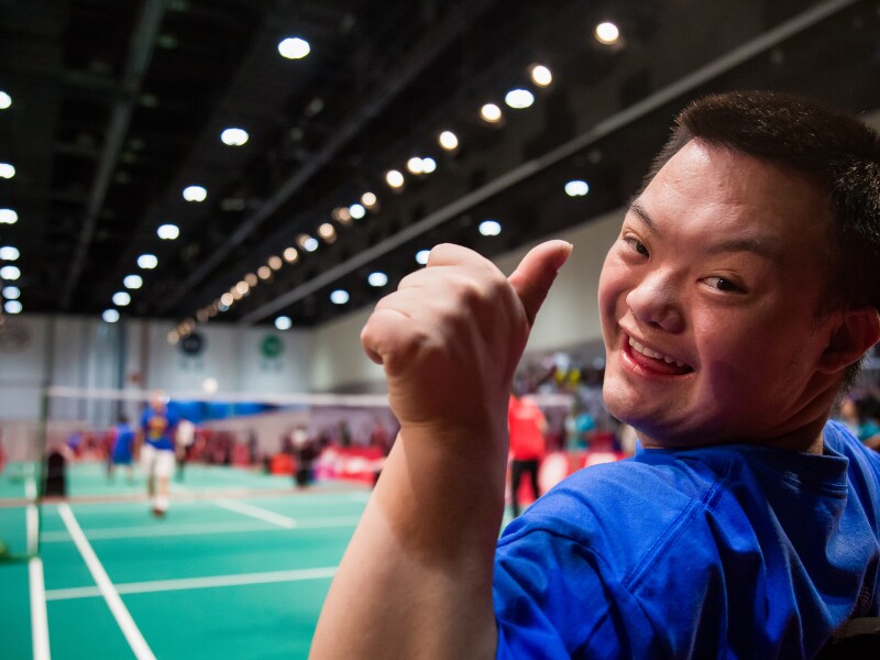 The photo shows a male Badminton player who holds his thumb up.