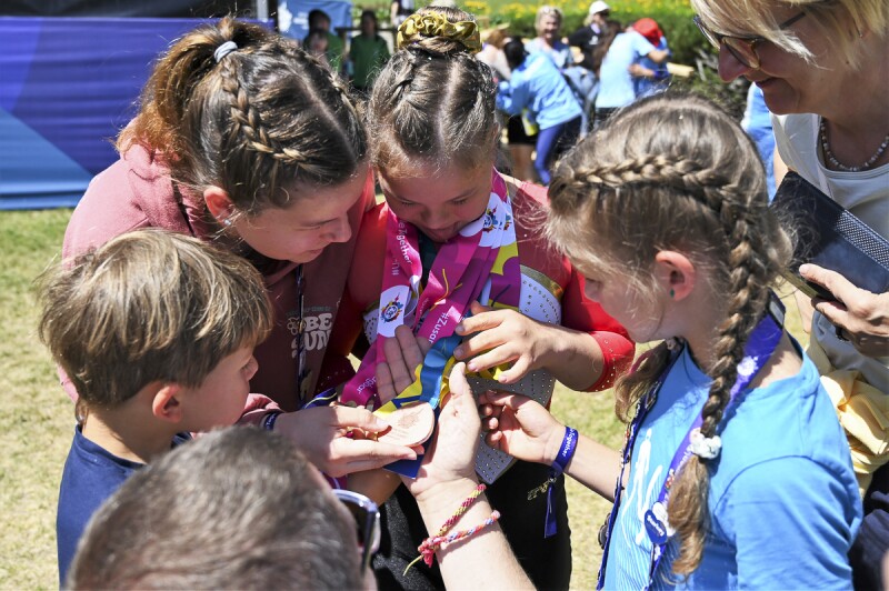 Annabelle showing her medal to family and friends