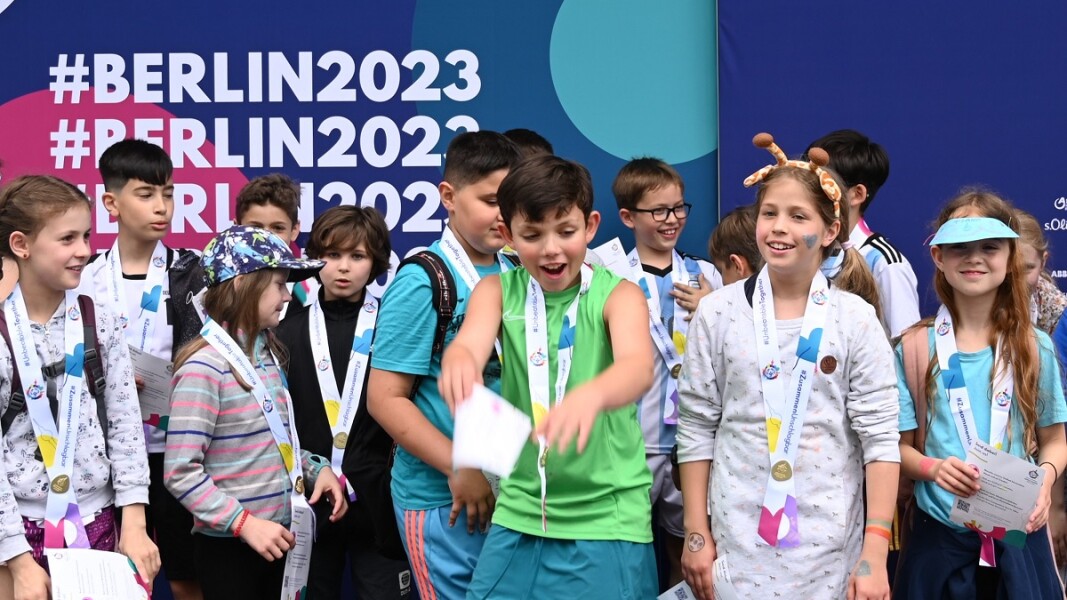 Auf dem Foto sind Kinder sich ausgelassen über eine Medaillie in der Activity Zone freuen.