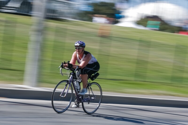 The photo shows an athlete on her bike during a triathlon competition.
