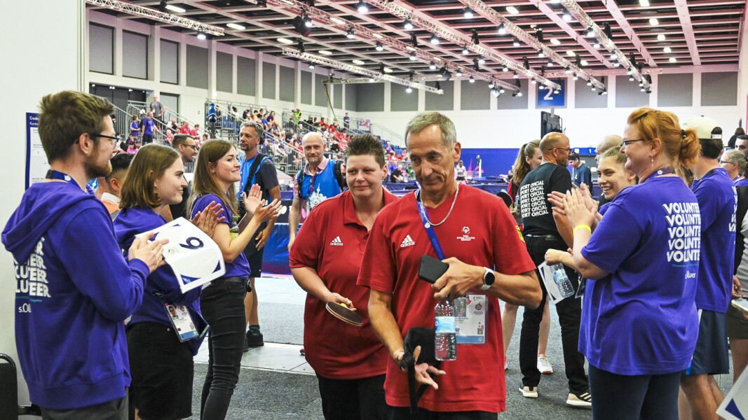 In the photo, a delegation of volunteers welcomes the German table tennis team after a successful match.