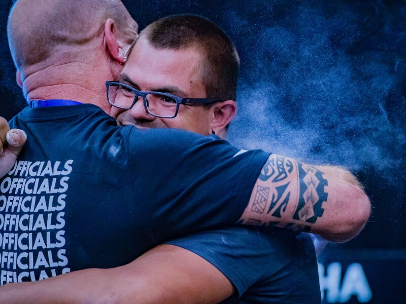 The photo shows a sports official and an athlete embracing.