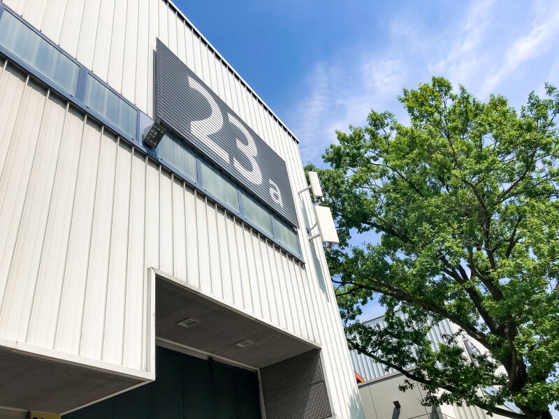 Das Foto zeigt den Anschnitt einer großen weißen Halle mit der Aufschrift 23a.