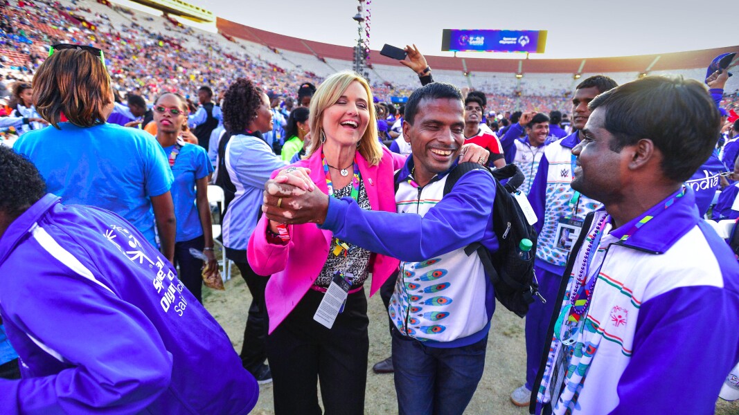 Auf dem Foto ist eine Menschenmenge im Stadion zu sehen. Im Fokus sind eine Frau und ein Mann, die gerade glücklich lächelnd miteinander tanzen.