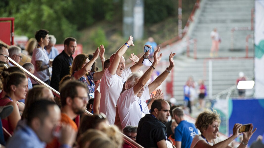 Das Foto zeigt die jubelnde Menge bei der Eröffnungsfeier der Nationalen Spiele Berlin 2022. Alle haben ihre Arme freudig nach oben gerissen.