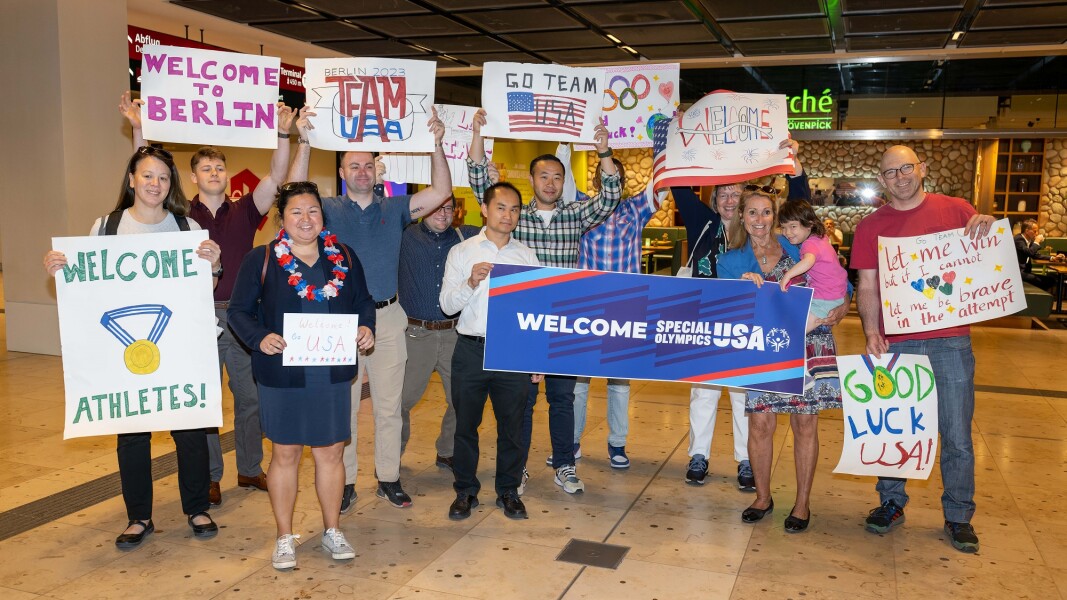 The photo shows representatives of the Host Town Bremen hosting the delegation of the USA for a few days before the World Games. They are holding various homemade pictures decorated with welcome messages and cheering into the camera.