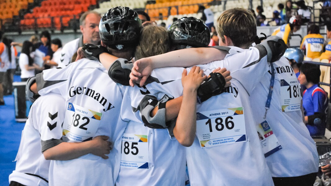 The photo shows a group hug of the German roller skating team.