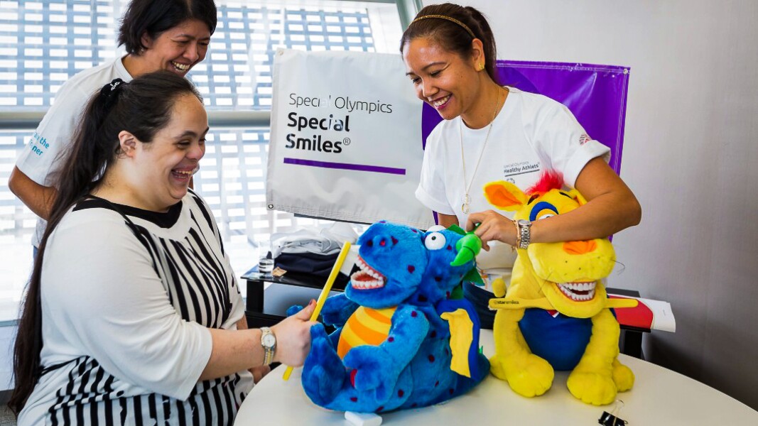 Das Foto zeigt ein Aufklärungsgespräch zum richtigen Zähneputzen während des Healthy Athletes Programs "Special Smiles".