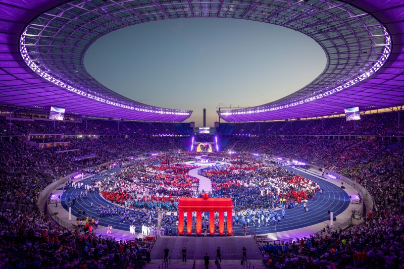 The photo shows the entire Olympiastadion at the opening ceremony. All delegations are in the center and the stadion is glowing.