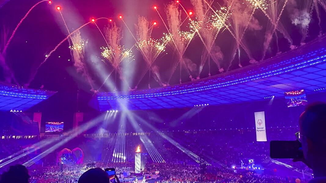 The photo shows the fireworks at the Opening Ceremony in the Olympiastadion. Spectators capture the moment with the camera.