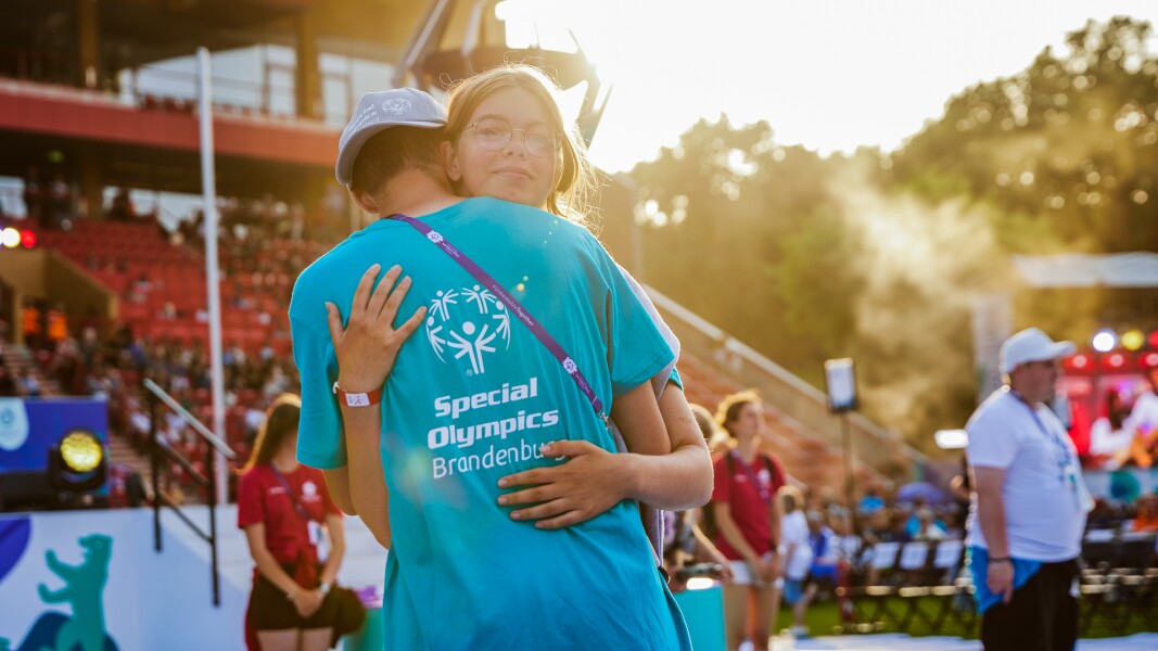Man sieht auf dem Foto zwei Menschen die sich herzlich umarmen.