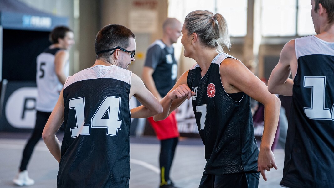 Das Foto zeigt einen Spieler und eine Spielerin beim 3x3 Basketball, die sich freuen.