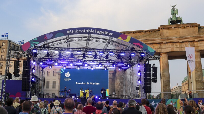 Das Foto zeigt unsere große Bühne am Brandenburger Tor während des Konzertabends im Rahmen des Special Olympics Festivals. Auf der Bühne sind Amadou & Mariam und viele Menschen hören begeistert zu.