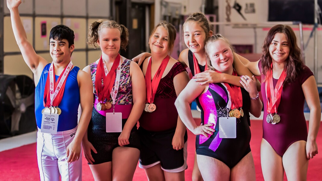 Das Foto zeigt Athlet*innen die sich umarmen.