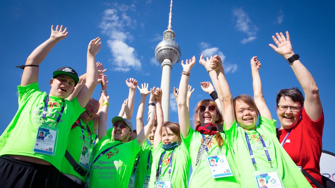 The photo shows a group of 0´9 athletes celebrating at the Special Olympics Festival right in front of the TV tower at Alexanderplatz.