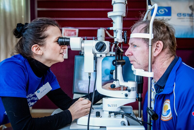 The photo shows two people during an Healthy Athletes eye examination. 