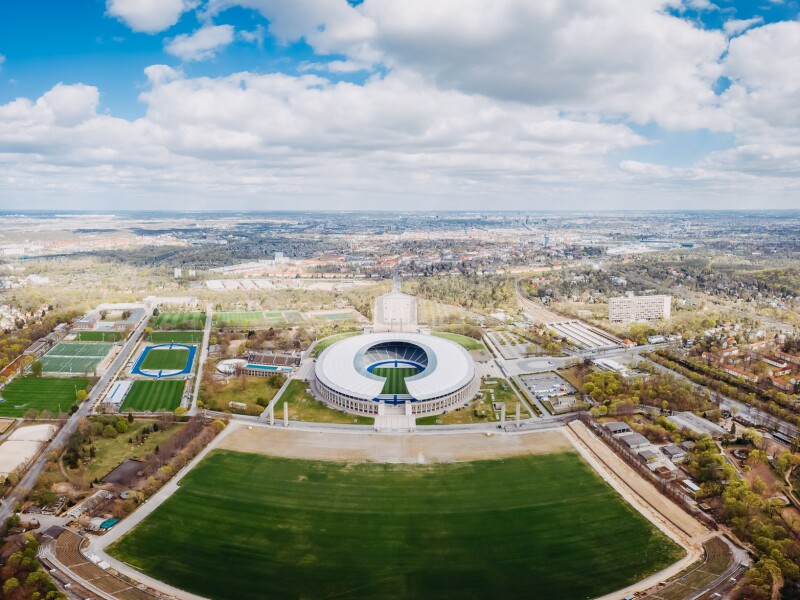 The photo shows an aerial view of the Olympic Park site.