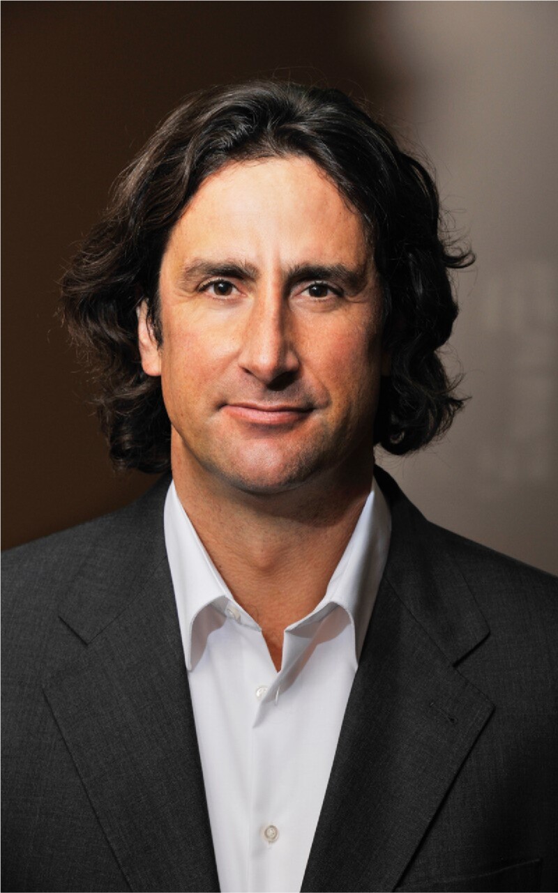The photo shows the former German track and field athlete Christian Schenk. He wears a suit and looks directly into the camera.