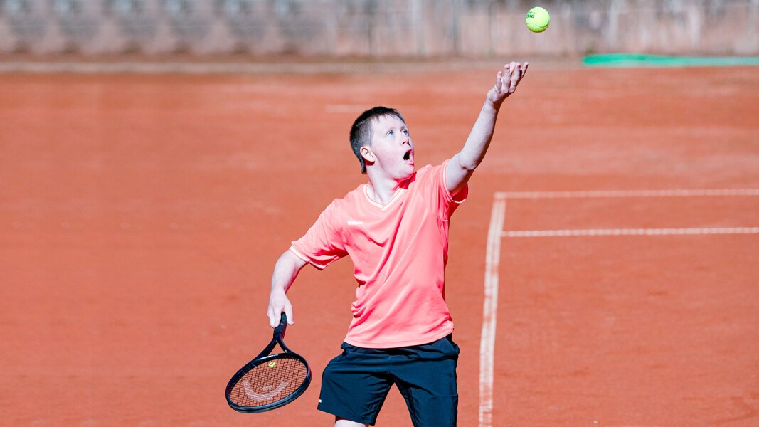 Das Foto zeigt einen Athleten im Tennis. Er ist gerade dabei einen Aufschlag zu machen.