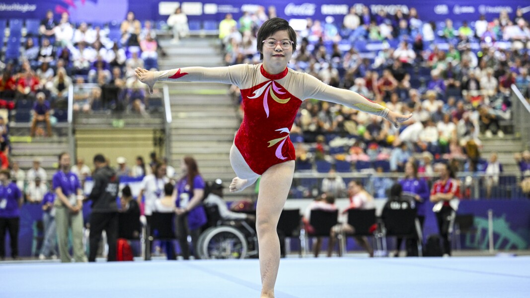 The photo shows an athlete. She is looking happily into the camera during a performance.