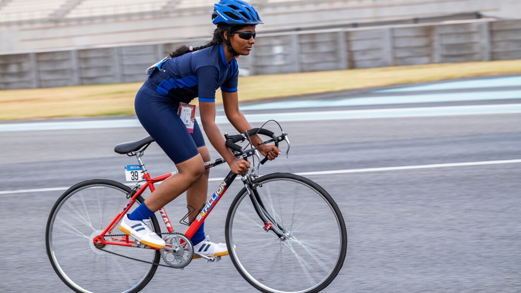 Das Foto zeigt eine Athletin beim Radfahren. Sie tritt in die Pedale.