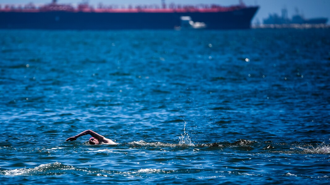 Auf dem Foto ist ein Schwimmer im offenen Wasser beim Triathlon zu sehen.