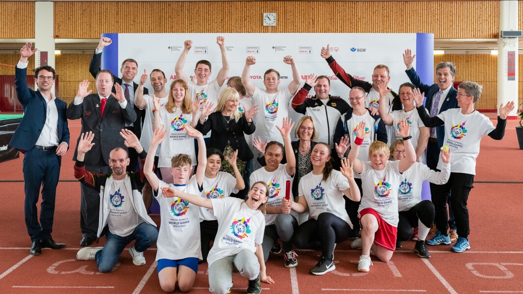 The photo shows all participants of the press conference, among other many athletes, Sven Albrecht, Timothy Shriver and Ian Harper. Everyone has their arms raised in joy.