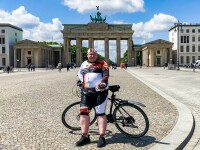Das Bild zeigt Special Olympics Deutschland Athlet Dennis Mellenthin mit seinem Fahrrad vor dem Brandenburger Tor.