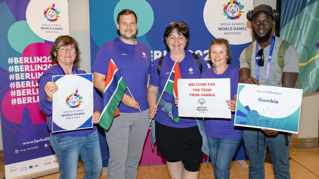 The photo shows representatives of the Host Town Wurzen hosting the delegation of Gambia for a few days before the World Games. They show signs with the official symbols of the World Games and the country Gambia and smile into the camera.