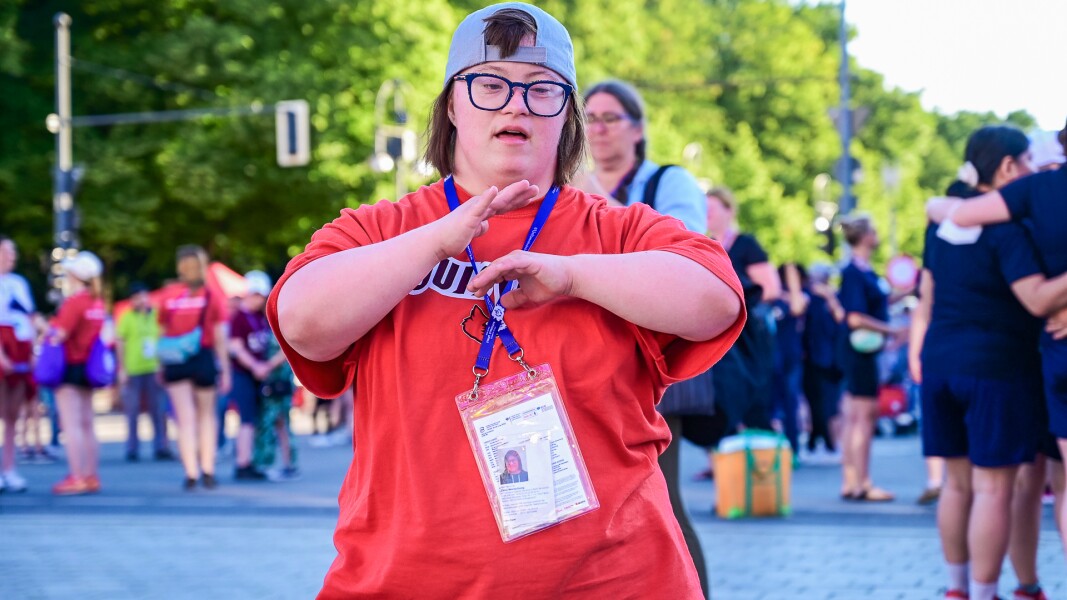 Auf dem Foto tanzt eine Athletin. Sie trägt ein Cap mit dem Schirm nach hinten und es sieht aus als ob sie rappt.