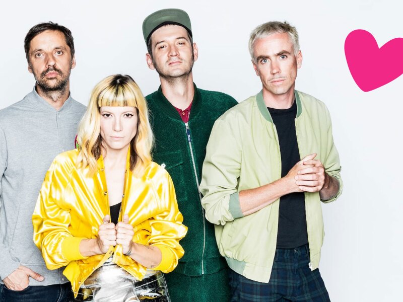 The photo shows the Berlin cult band MiA., which will perform at the Opening Ceremony of the National Games. The four band members are looking at the camera. In the corner is additionally placed a pink heart.