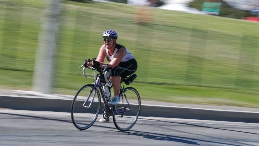 Das Foto zeigt eine Athletin beim Triathlon. Sie absolviert gerade die zweite Disziplin, das Radfahren.