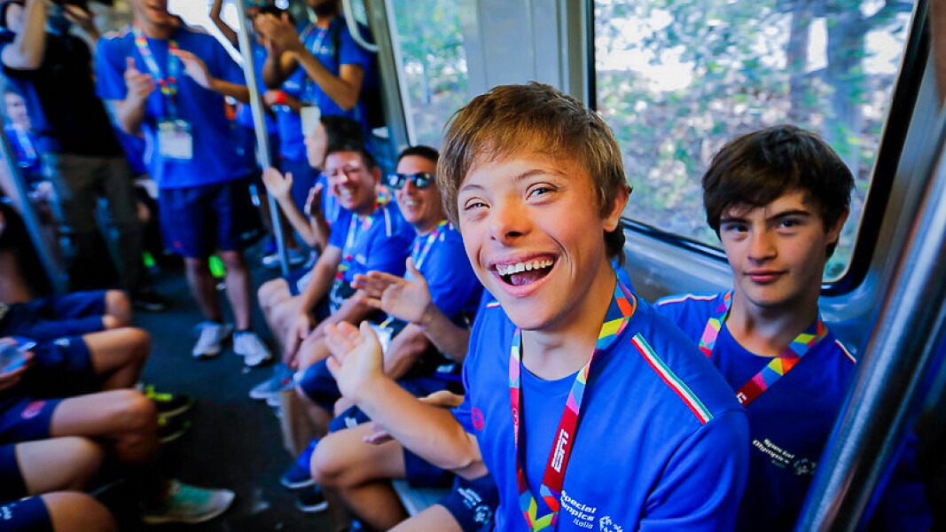 Das Foto zeigt Athleten der italienischen Delegation in einem Zug. Sie lachen in die Kamera und freuen sich.