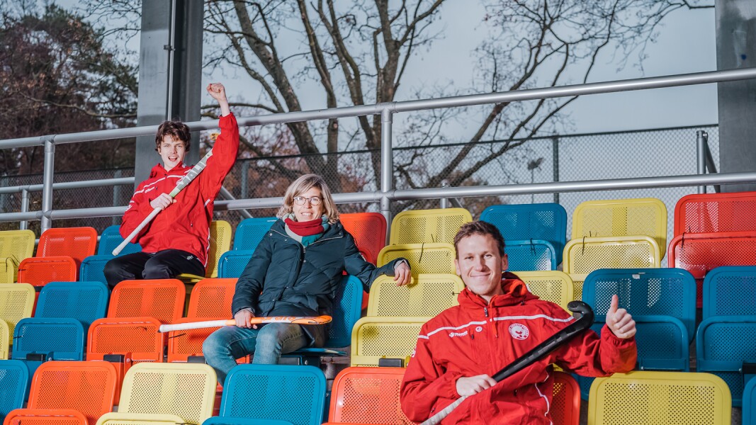 Das Foto zeigt zwei Athleten mit Natascha Keller. Alle halten Hockeyschläger in ihren Händen.