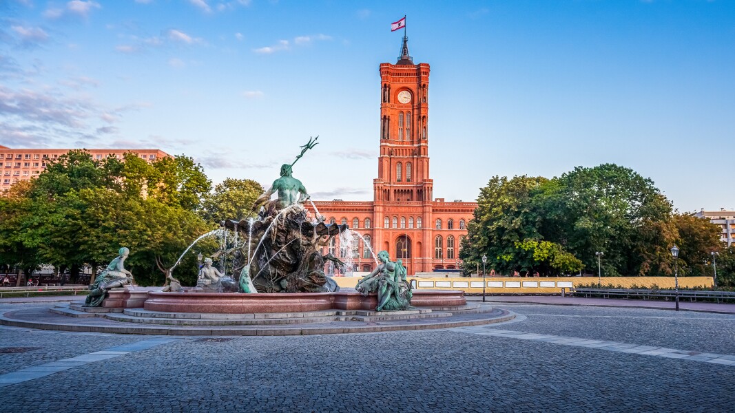 The photo shows the active Neptune Fountain and the Red Town Hall in Berlin in the background.