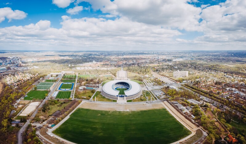 The photo shows an aerial view of the Olympic Park site.