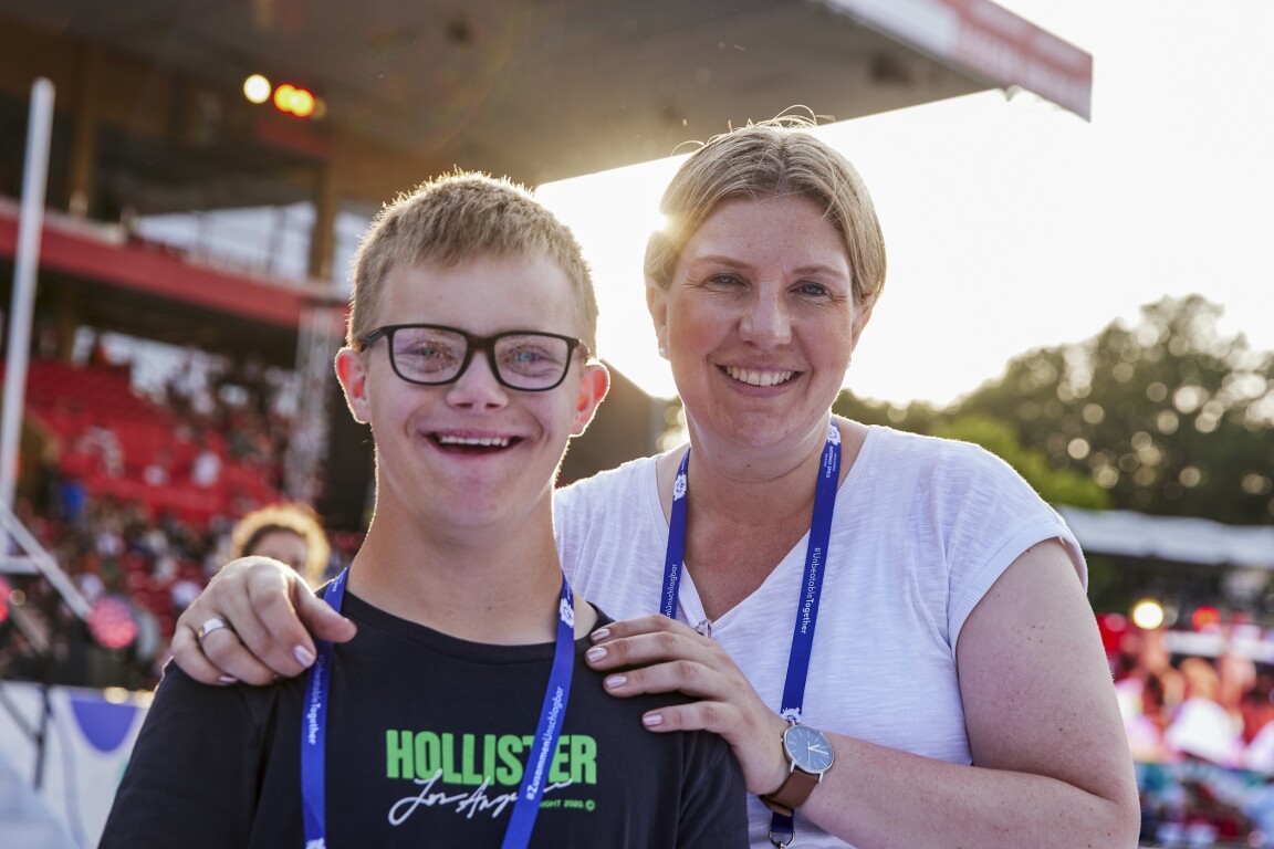 Auf dem Foto ist ein junger Athlet mit seiner Mutter zu sehen. Sie lächeln beide in die Kamera und haben Spaß auf der Eröffnungsfeier der Nationalen Spiele Berlin 2022.